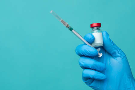 Syringe and ampoule with medicine in doctor's hand, vaccination