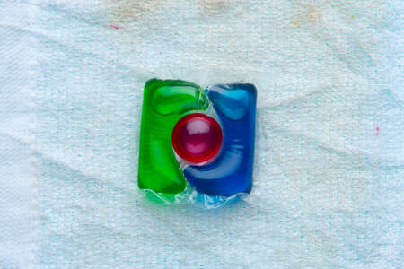 one water-soluble capsule for washing clothes and a dirty towel