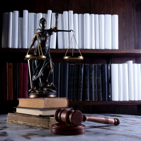 Scales of Justice, Lady Justice, law library concept, Law books in the background.