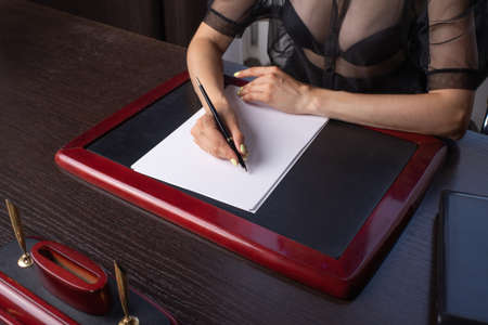 Close-up Of Businesswoman's Hand Signing On Papers Over Deskの写真素材