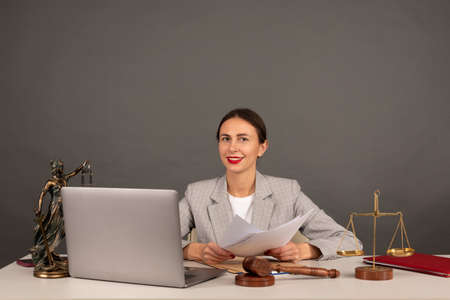 Lawyer office. Statue of Justice with scales and lawyer working on a laptop. Legal law, advice and justice conceptの写真素材
