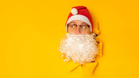 DJ Santa Claus in headphones. Christmas songs and music. yellow background.の写真素材