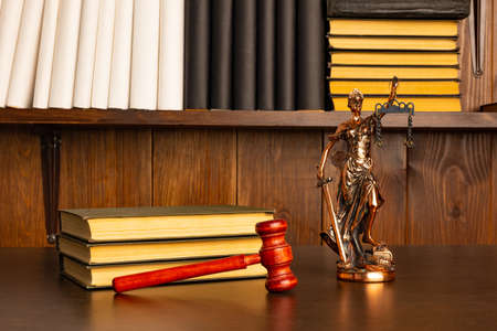 Lady Justice, Judge's gavel, books on an old wooden table