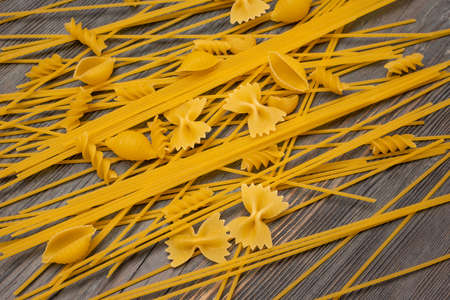 top view Various types of Italian pasta on wooden background