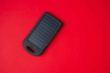 clean energy solar battery powerbank top view on red backgroundの写真素材