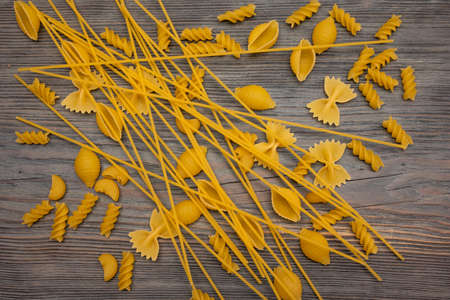top view Various types of Italian pasta on wooden background