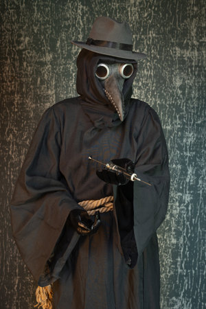 Plague doctor with a syringe of medicine or poisonの写真素材