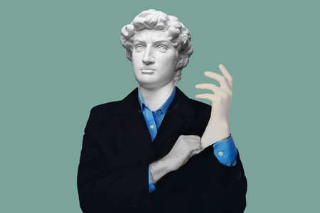 Abstract modern collage. The man with the plaster head of David in suit and blue shirt puts on medical glove on blue backgroundの写真素材