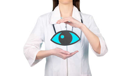 Female doctor with a stethoscope is holding mockup eye in the hands. Help and care conceptの写真素材