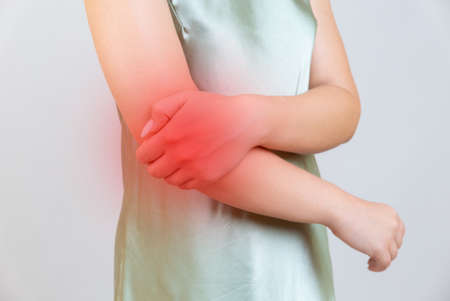 young woman experiencing pain in elbow jointの写真素材