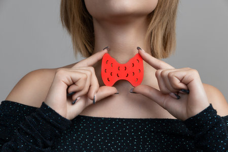 Young asian woman is holding mockup thyroid gland. Help and care concept