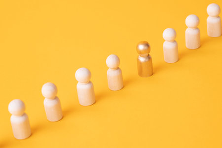 An employee figurine comes out of a row of colleagues. Promotion at work, appointment to the role of team leader. Dismissal of an employee. Take the first step, be different. initiative and inspirationの写真素材