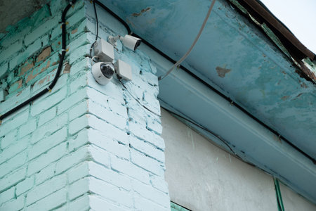 CCTV security camera system being used for surveillance purposes placed on a brick wall with copy...