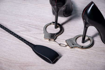 adult sex games. Kinky lifestyle. Spank with a pair of black high-heeled shoes and handcuffs. bdsm...