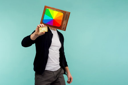 Modern minimal retro collage art. Retro Tvguy holds a gold credit card in his handの写真素材