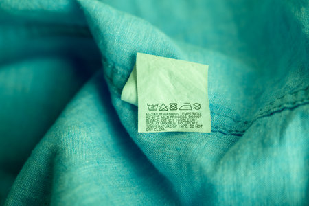 Clothing label on light green garment, top viewの写真素材