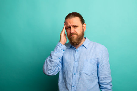Elegant beard senior man over isolated background with hand on head for pain in head because stress....