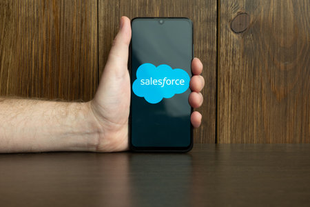 Kyoto city, Japan - July 31, 2023: Salesforce.com displayed on a smartphone near modern laptop on wooden backgroundのeditorial素材