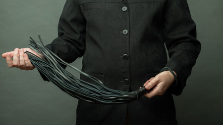 male dominant holds a leather whip Flogger for hard BDSM sex with spankingの写真素材