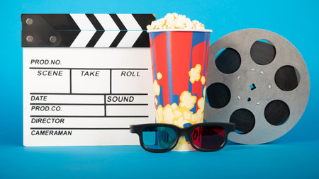 Movie clapper, pop corn, 3D glasses and film reel on blue background. collage designの写真素材