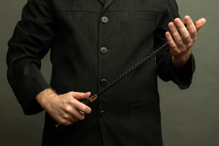 male dominant holds a leather whip Flogger for hard BDSM sex with spanking