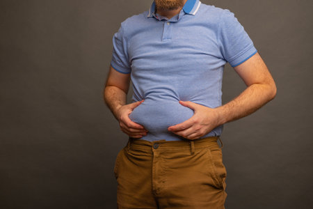 Overweight man in t-shirt on gray background, closeup. Space for textの写真素材