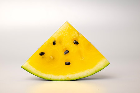 Fresh yellow watermelon slice on background, juicy delicious cut watermelon with a yellow coreの写真素材