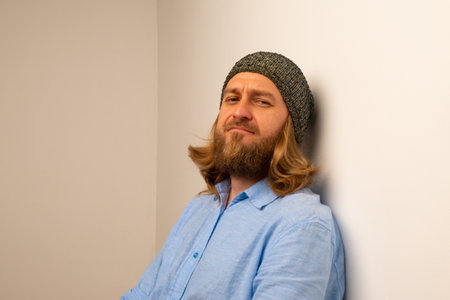 Confident man wearing knit hat by wallの写真素材