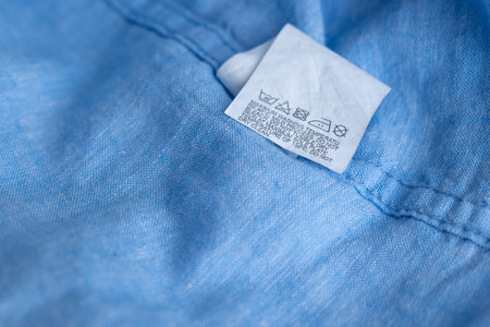 Clothing label on light blue garment, top viewの写真素材