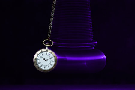 Hypnosis session. Vintage pocket watch with chain swinging over surface on dark background among faded clock faces, magic motion effectの写真素材