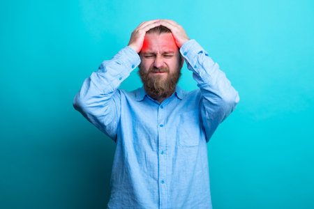 Elegant beard senior man over isolated background with hand on head for pain in head because stress. Suffering migraine.の写真素材