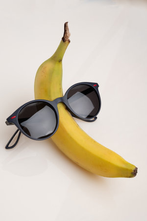 A funny banana with black sunglasses on a white background.の写真素材