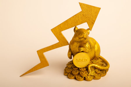 A figurine of a mouse with a gold coin. Gold price and rising chart. Business and finance concept.の写真素材