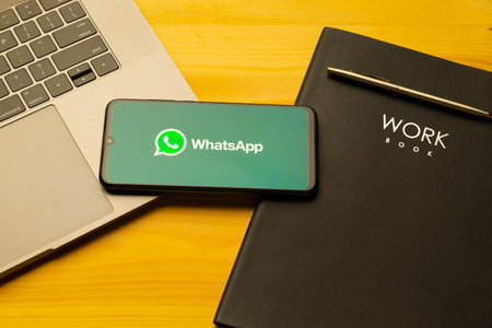 Kyoto city, Japan - July 31, 2023: Apple iPhone with Whatsapp logo on the screen on wooden backgroundのeditorial素材