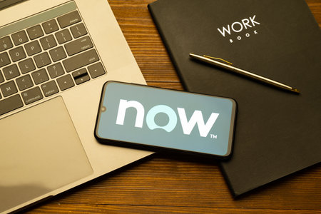Kyoto city, Japan - July 31, 2023: Logo Servicenow on a smartphone near modern laptop on yellow wooden backgroundのeditorial素材