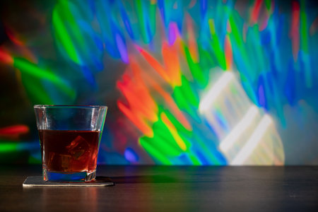Glass of whiskey on the bar in front of the blur image