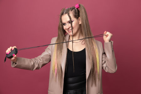 Beautiful young woman with lots of computer cables over her head, peeking behind a computer mouseの写真素材