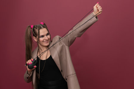 Beautiful young woman with lots of computer cables over her head, peeking behind a computer mouseの写真素材