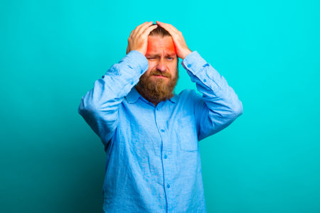 Elegant beard senior man over isolated background with hand on head for pain in head because stress....