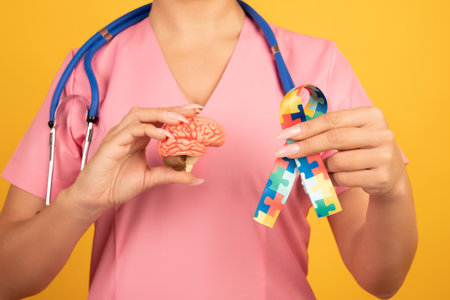 Female doctor is holding anatomical model human brain with Puzzle pattern ribbon. Help and care conceptの写真素材