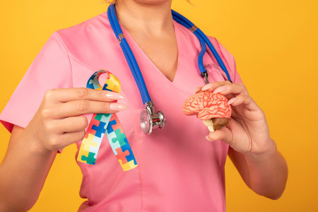 Female doctor is holding anatomical model human brain with Puzzle pattern ribbon. Help and care conceptの写真素材