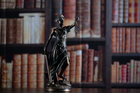 Law and wisdom. Statue of Lady Justice near shelves with books.