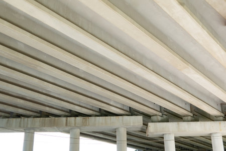 Abstract industrial photo with bottom view of a road bridge with concrete pillars.の写真素材