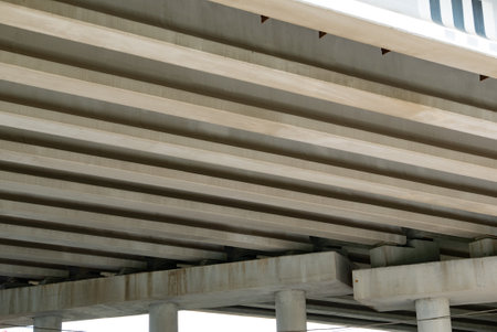 Abstract industrial photo with bottom view of a road bridge with concrete pillars.の写真素材