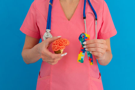 Female doctor is holding anatomical model human brain with Puzzle pattern ribbon. Help and care conceptの写真素材