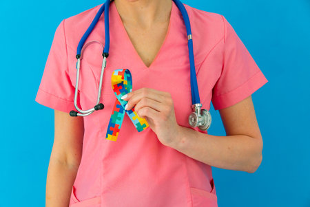 World Autism awareness and pride day with Puzzle pattern ribbon. The doctor's handの写真素材