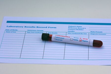 Blood test tube sample, coronavirus negative test result on a laboratory results record form...