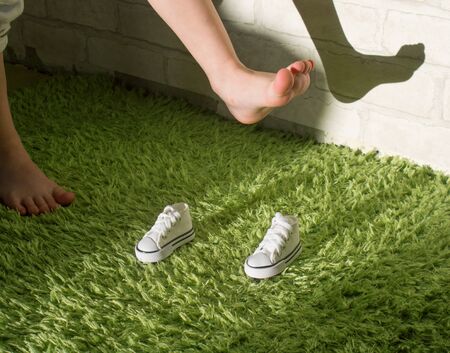The feet of the child have grown large, and the shoes are very small. Concept of new shoes for...