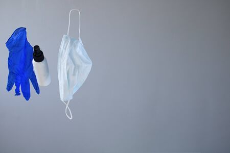 Levitating Epidemic Protective kit, Masks pile, gloves and alcohol hand sanitizer bottle on gray background. Copy space, place for text, trendの写真素材