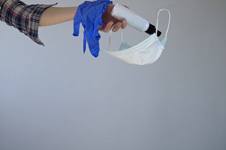female hand throws out a mask, gloves and a disinfectant. Quarantine end and coronavirus is over....